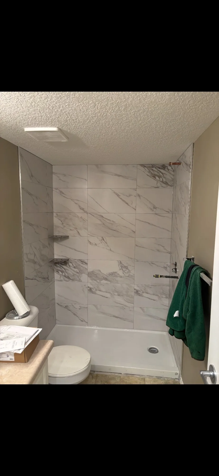 Calgary bathroom tile reno — marble-look porcelain tub-shower walls with built-in shelving
