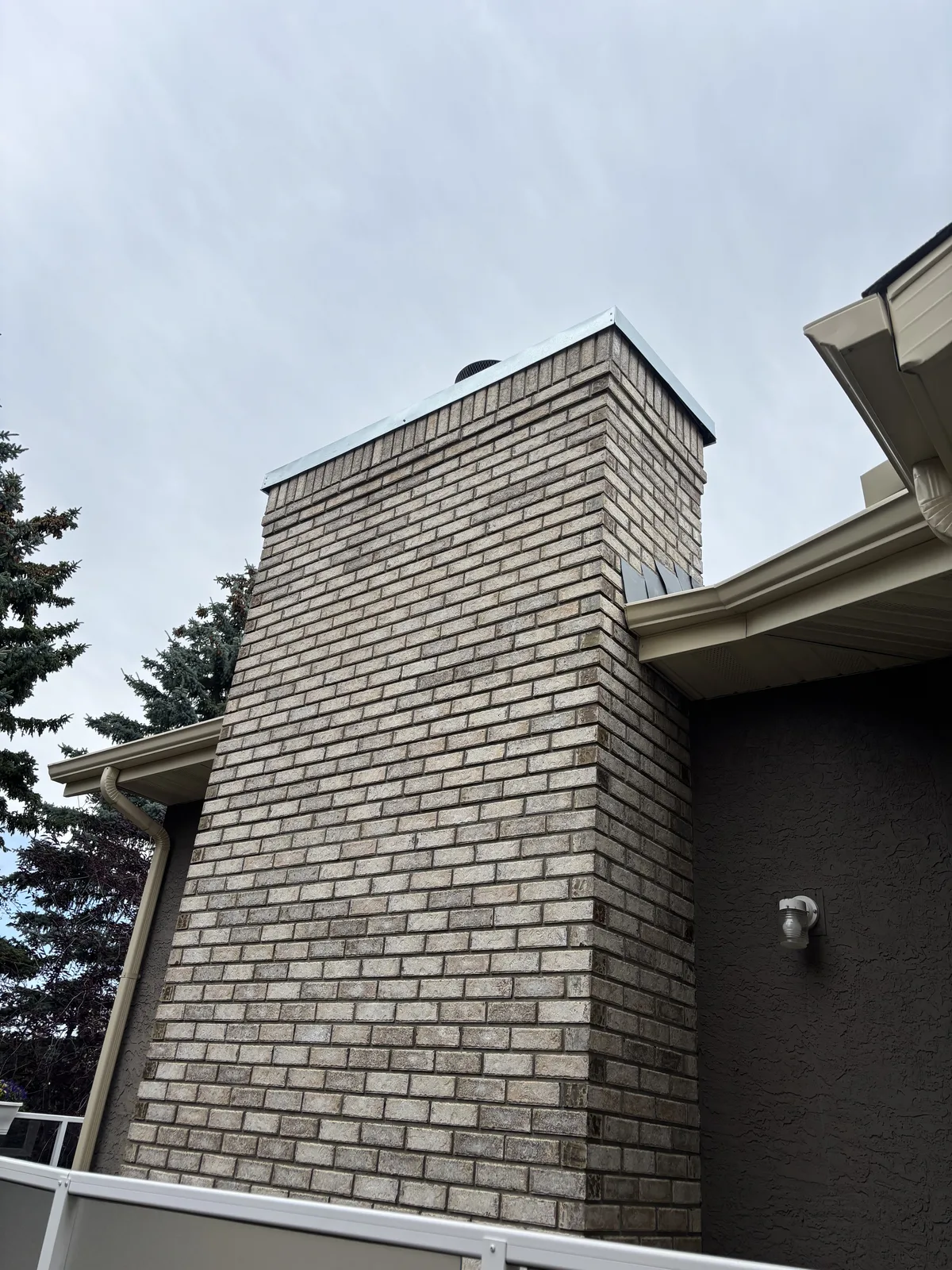 Rebuilt brick chimney on a Calgary home with a new metal cap
