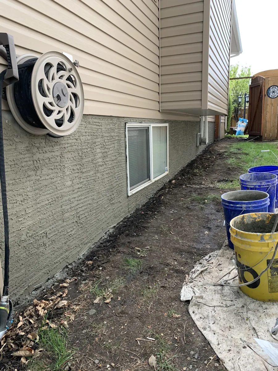 Calgary foundation parging after repair — fresh grey finish, weather-tight