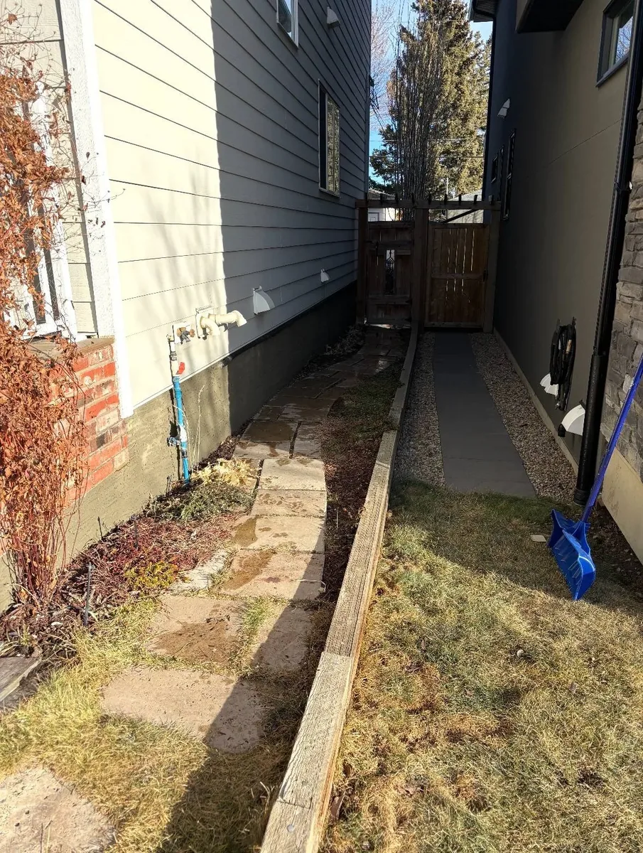 Calgary sidewall foundation after parging — fresh polymer-modified parging applied along the side yard foundation strip