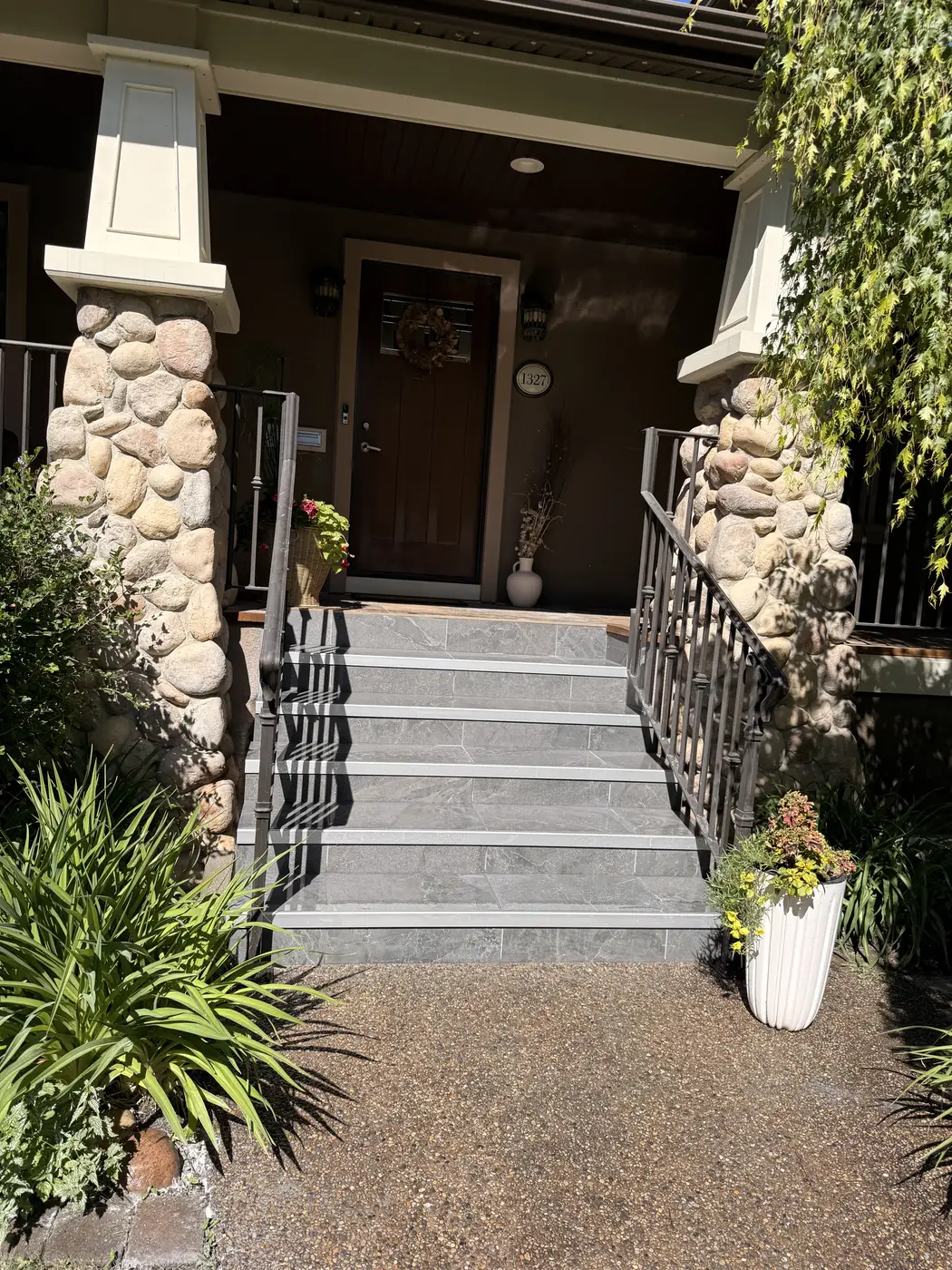 Front entry stairs in Calgary after renovation, slate treads and risers between river-rock pillars