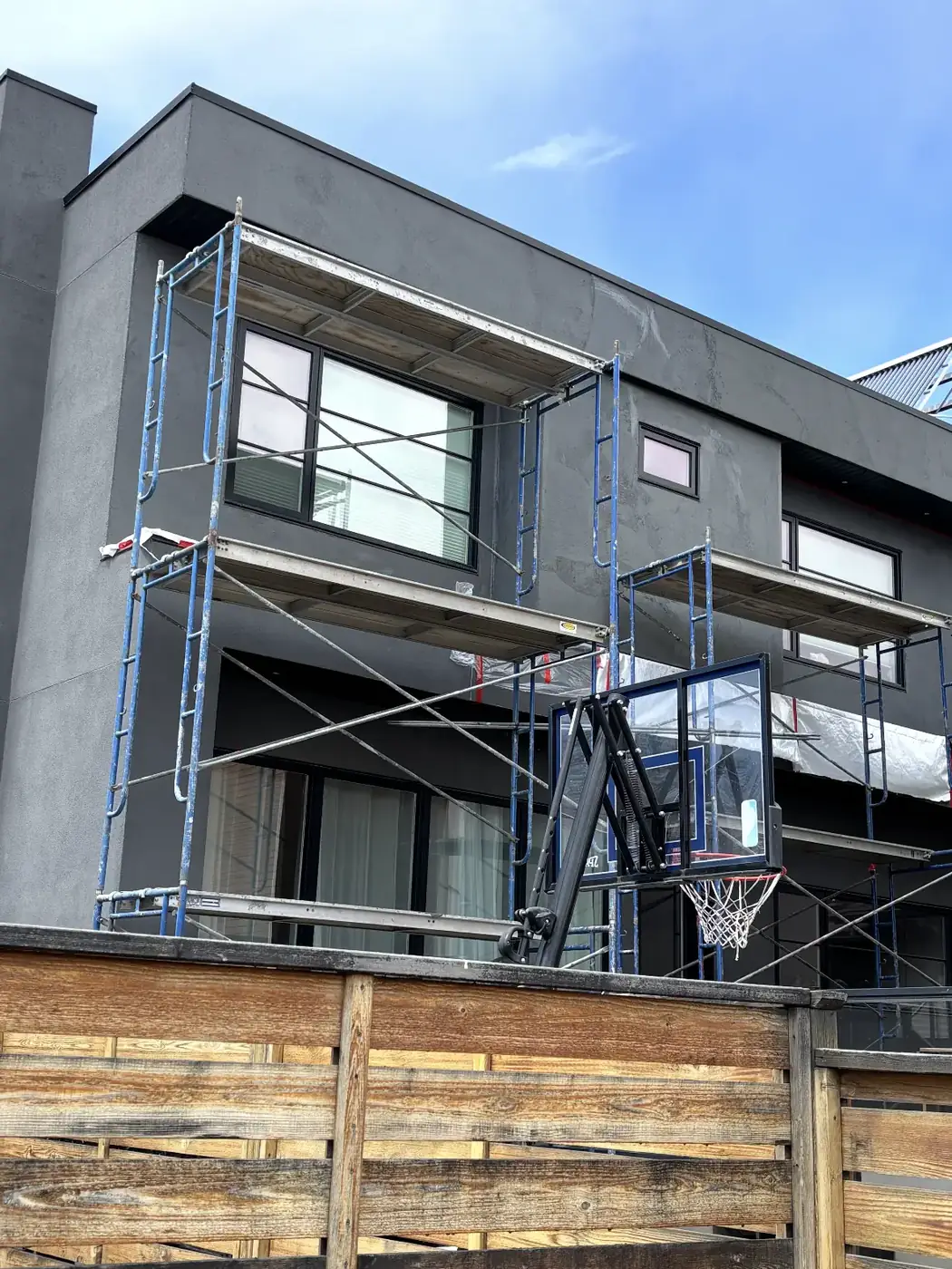 Full-wall application in progress on a Calgary home, scaffolding up