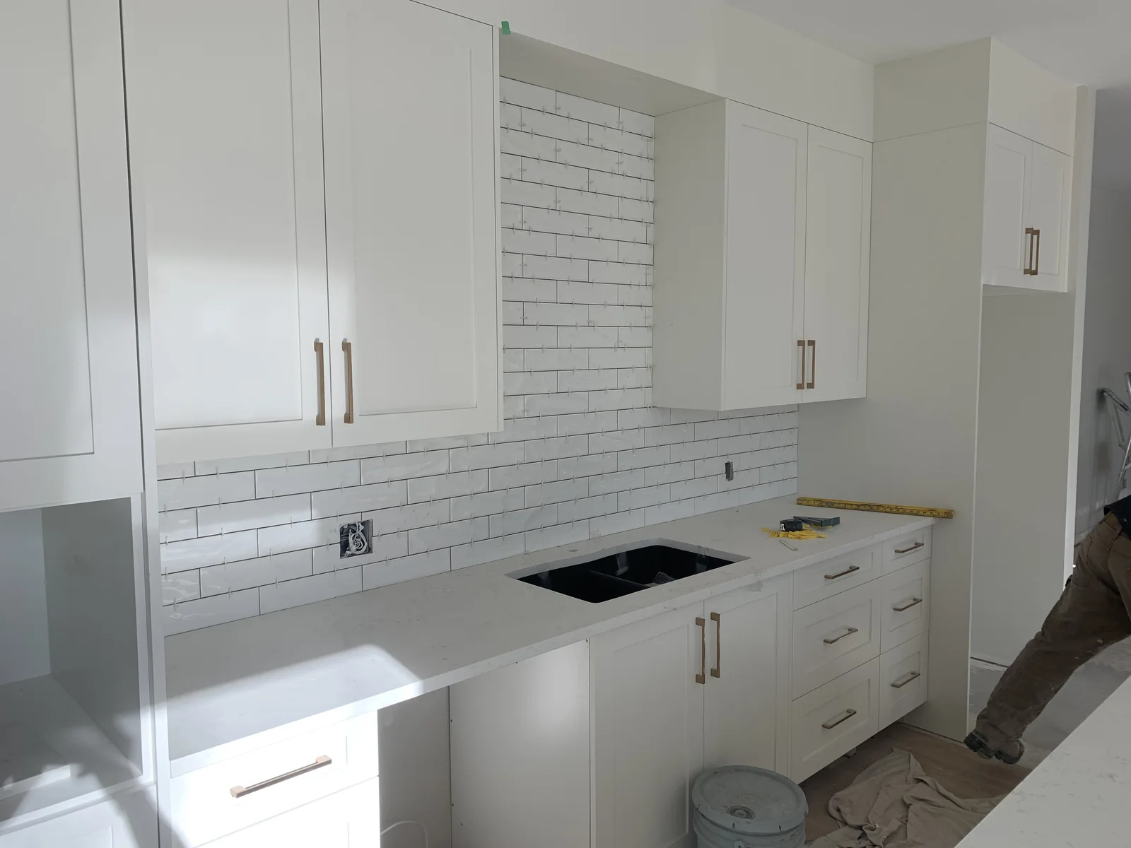 Calgary kitchen backsplash tile installation, gloss white subway tile with new white cabinetry and black undermount sink