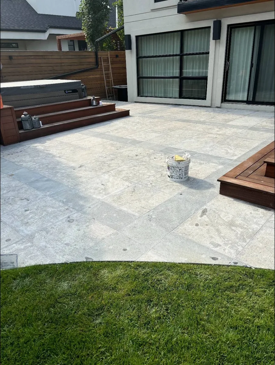 Calgary outdoor patio tile installation — frost-rated porcelain pavers on backyard patio next to hot tub deck