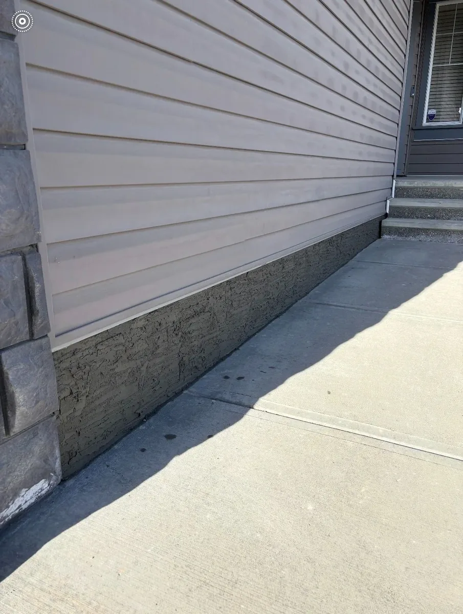 Calgary parging repair after — fresh polymer-modified parging applied, smooth uniform finish along the foundation strip