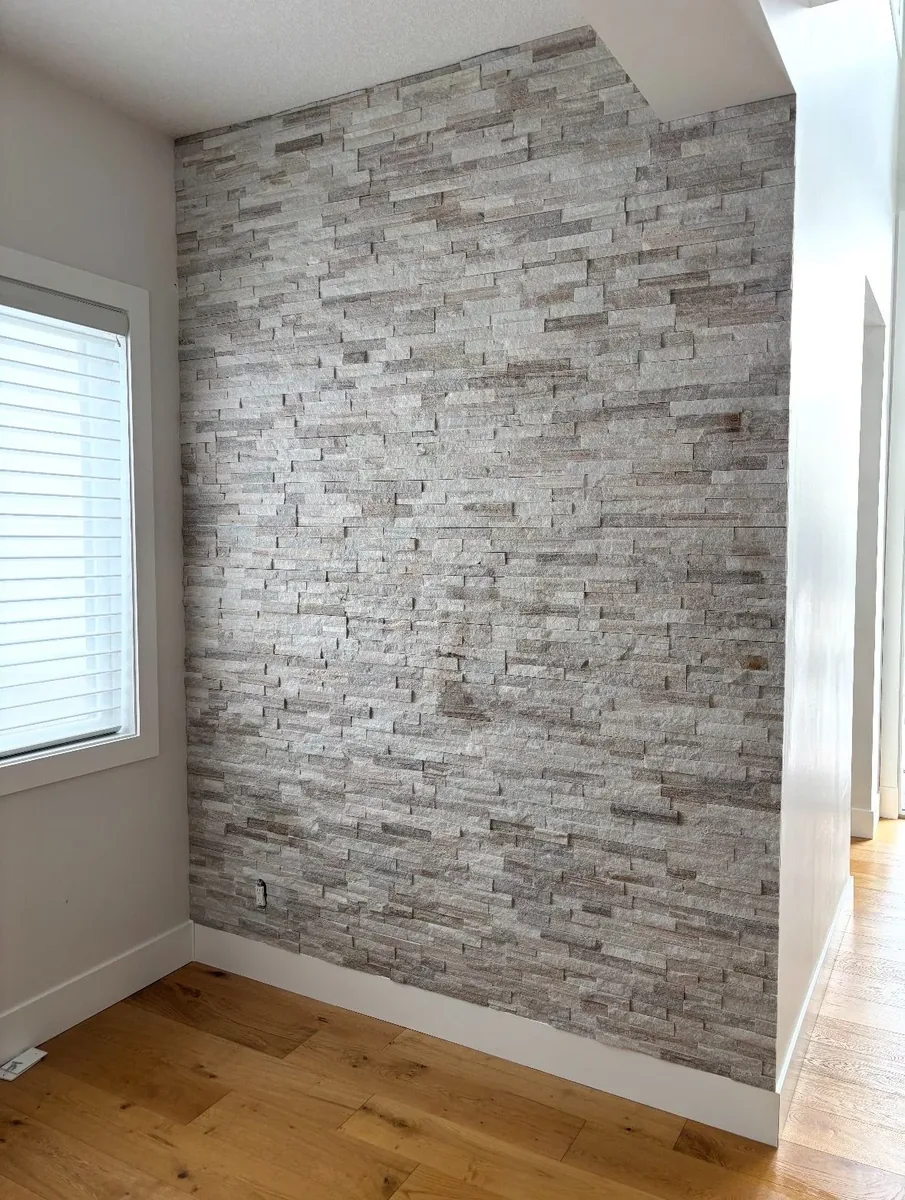 Calgary interior stone accent wall completed — full floor-to-ceiling stacked ledgestone feature wall, clean finish
