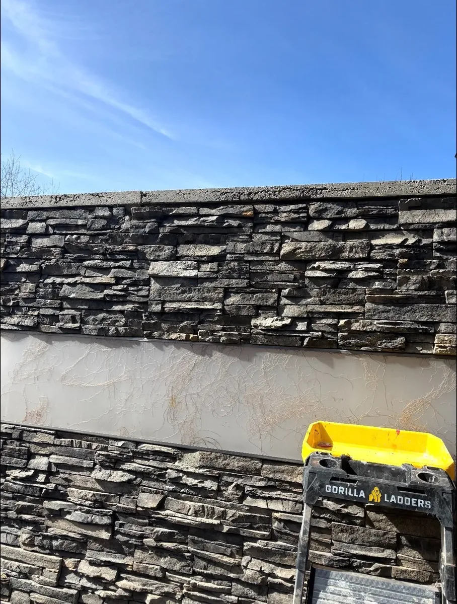 Calgary stone wall after repair — fallen stones cut back, reset, and re-pointed with matching dark slate veneer