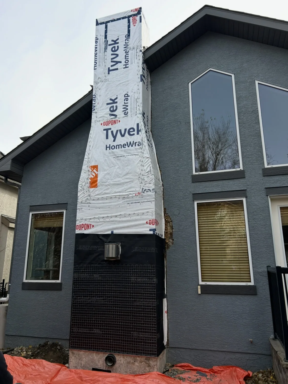 The same Calgary stucco chimney chase stripped to the housewrap before new stucco