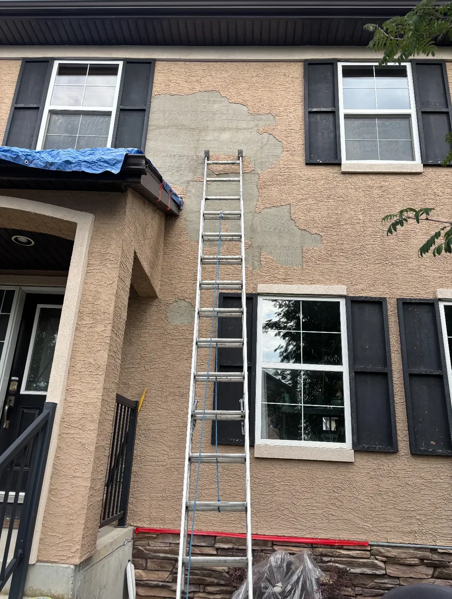 Calgary stucco wall before finish re-coat — failing top coat visible