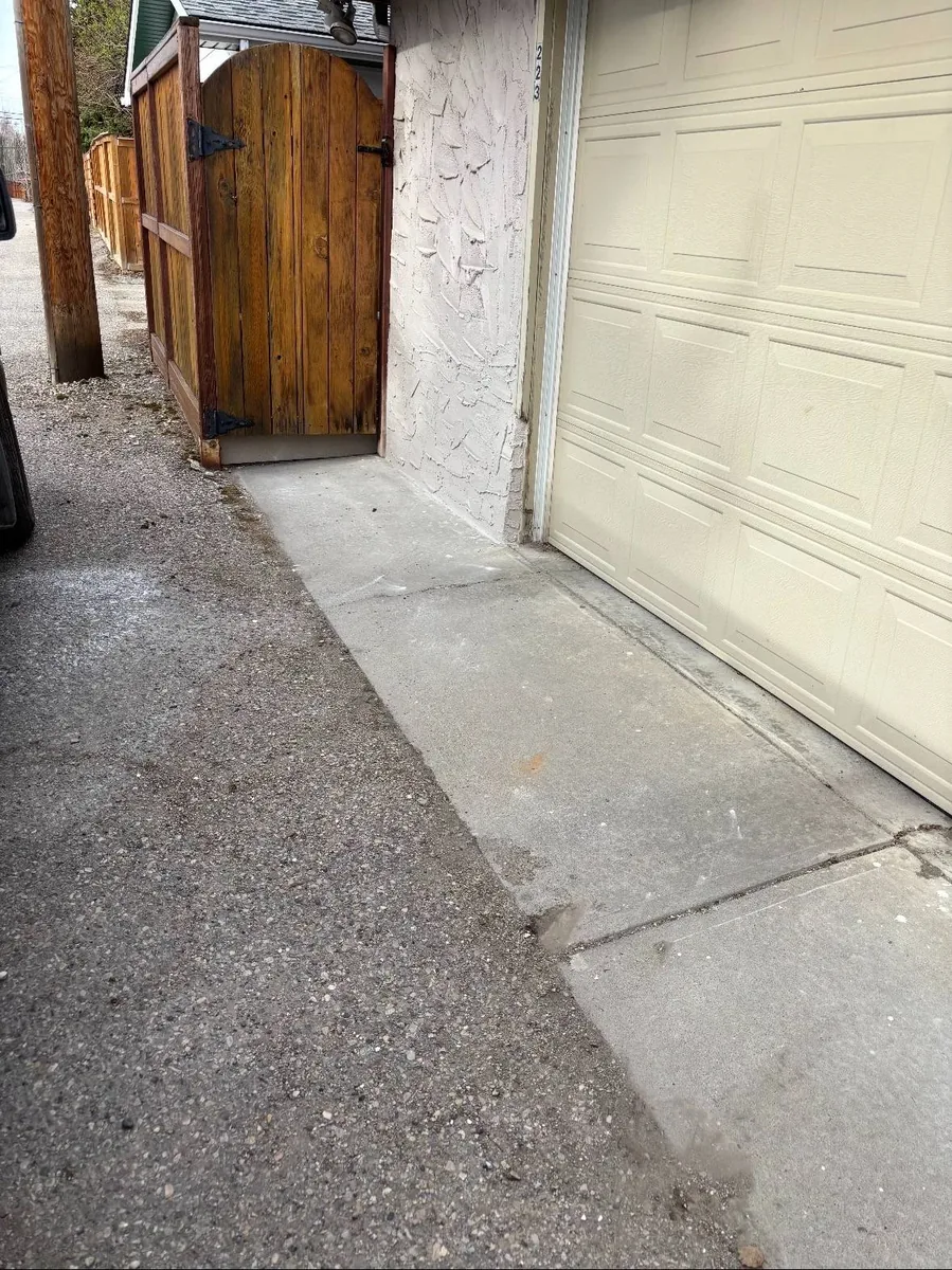 Calgary garage wall stucco repair after — clean re-built stucco at grade, weather-tight