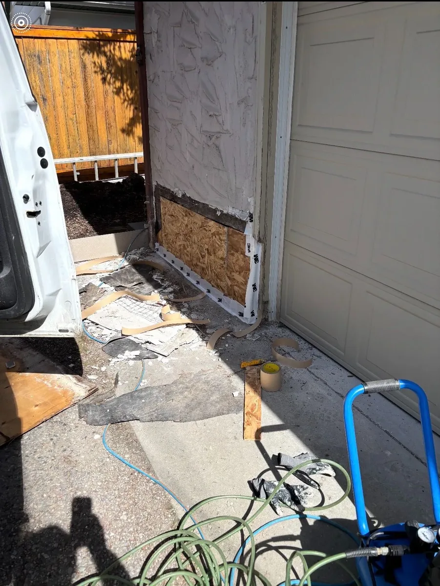 Calgary garage wall stucco leak repair before — exposed OSB sheathing, water-damaged stucco removed, 3M flashing tape installed