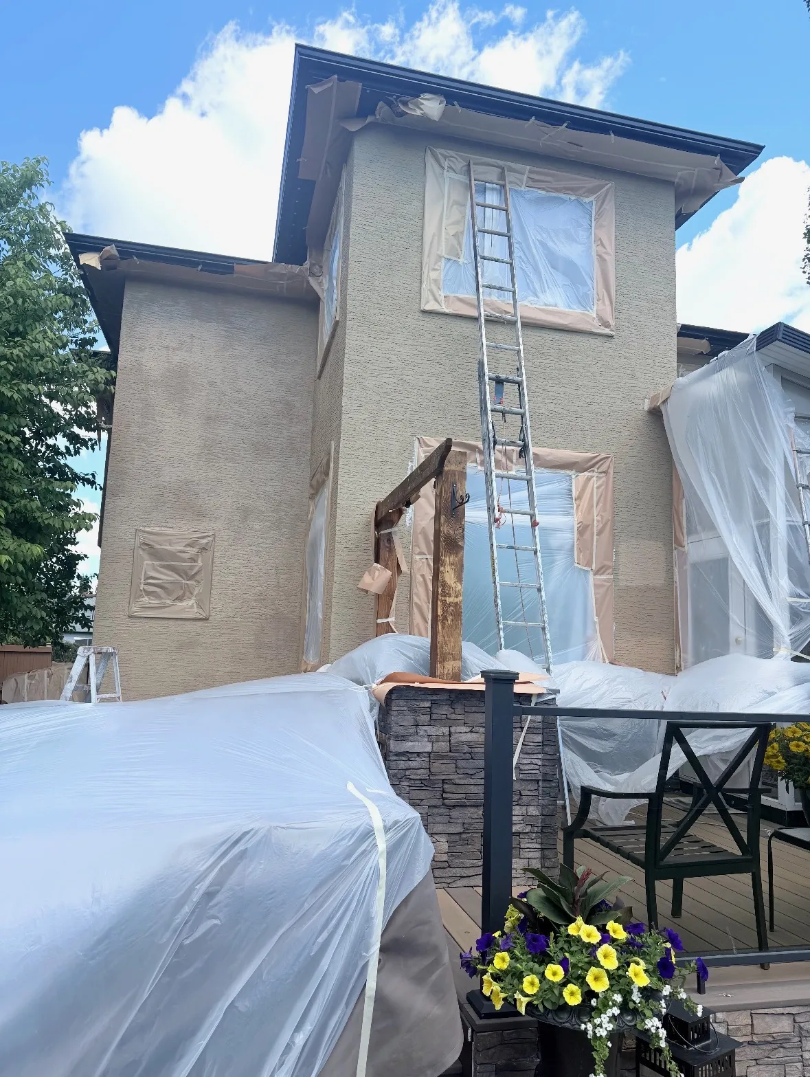 Two-storey Calgary house wrapped in plastic and masked off before stucco painting