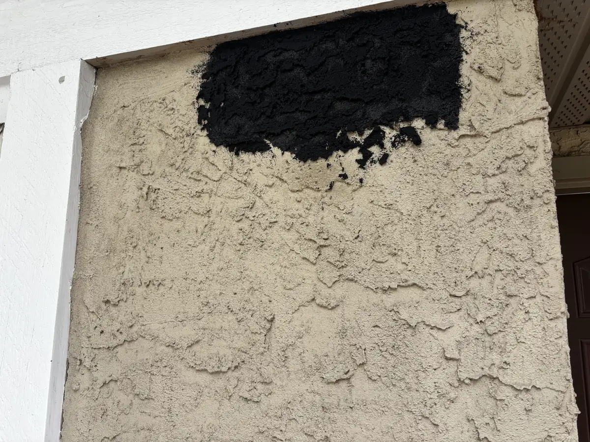 Close-up of black Graphex coating troweled onto Calgary stucco, dense fibre-reinforced texture