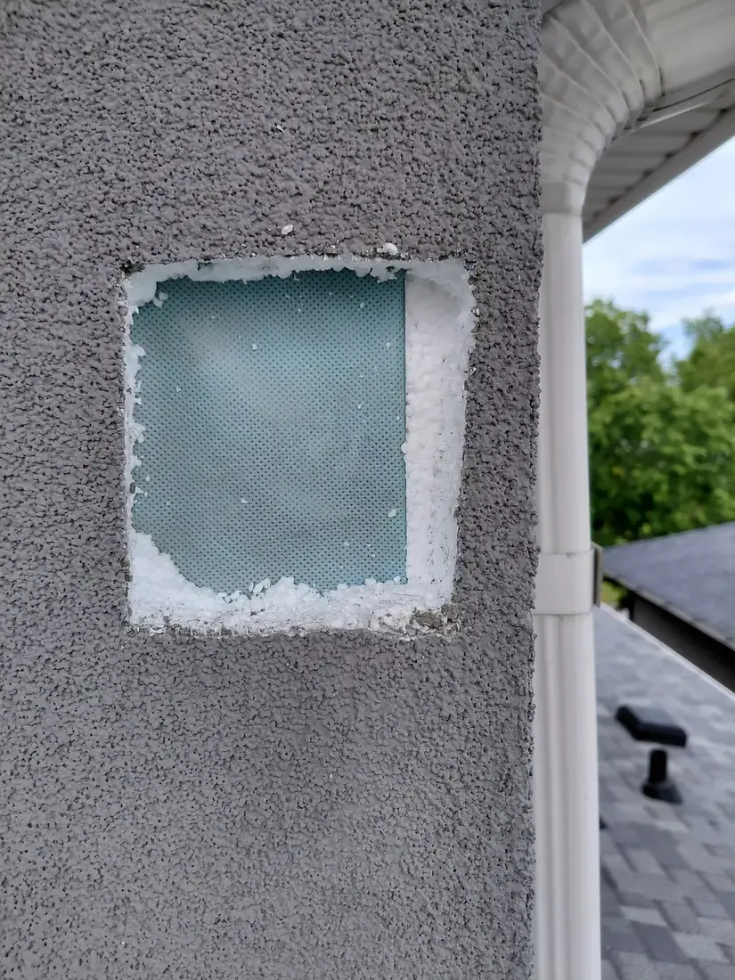 Woodpecker damage cut back to a clean square opening in the EIFS, weather barrier intact behind
